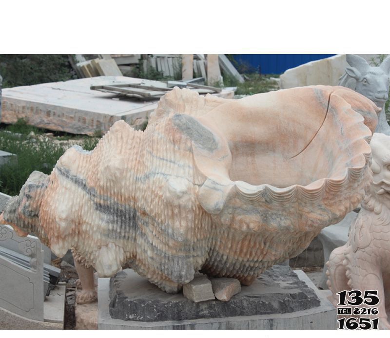 海螺雕塑-花池边摆放的花岗岩石雕创意海螺雕塑高清图片