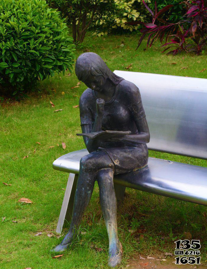 读书雕塑-公园铜雕坐着长椅上的女孩读书雕塑高清图片