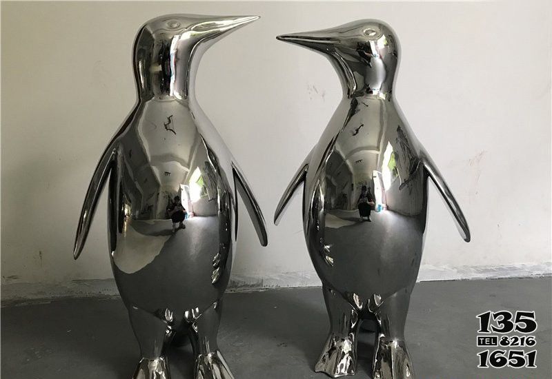 企鹅雕塑-游乐场不锈钢镜面休息中的企鹅雕塑高清图片