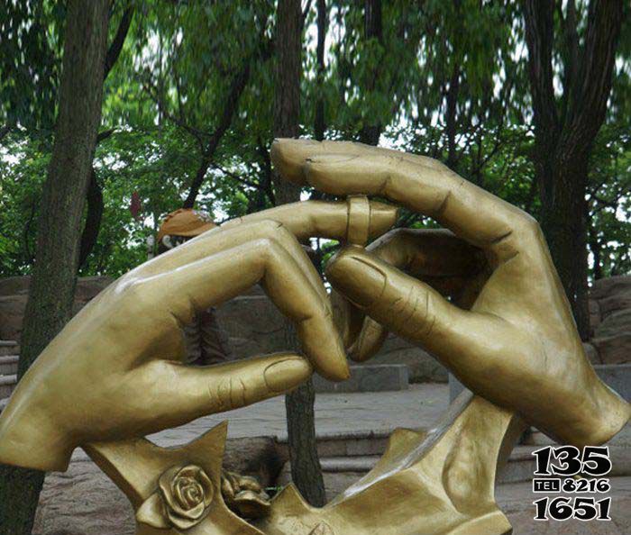 戒指雕塑-公园小区镀金手戴戒指黄铜戒指雕塑高清图片