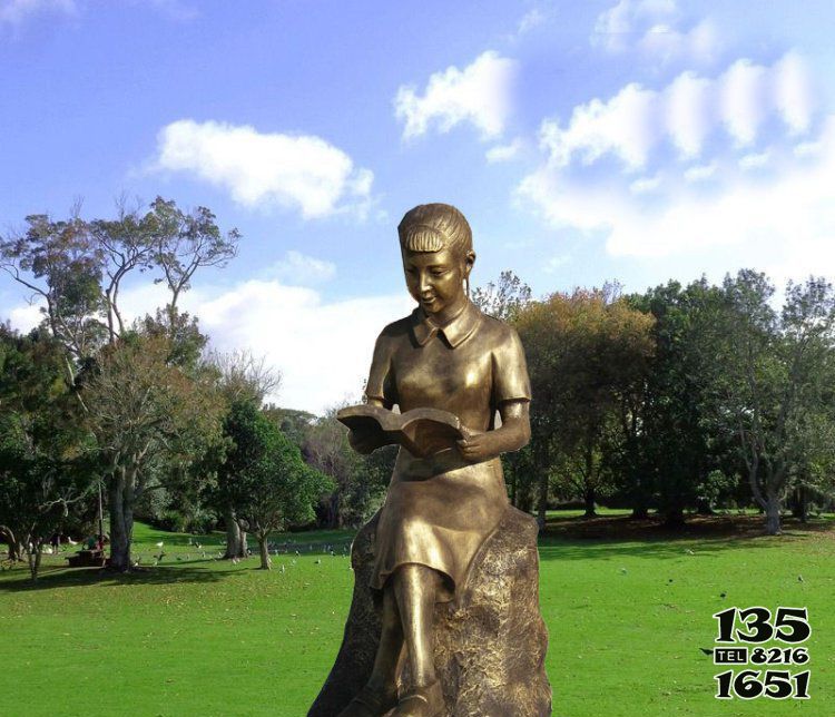 读书雕塑-公园草坪女孩坐着石头上的读书雕塑高清图片