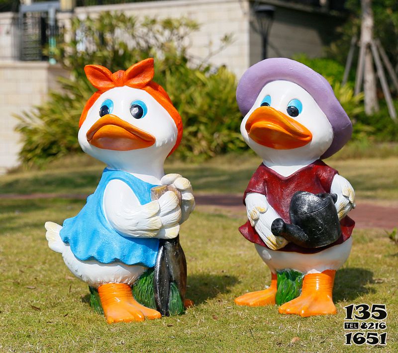 鸭子雕塑-草坪上手拿剪刀和水壶的玻璃钢彩绘鸭子雕塑高清图片