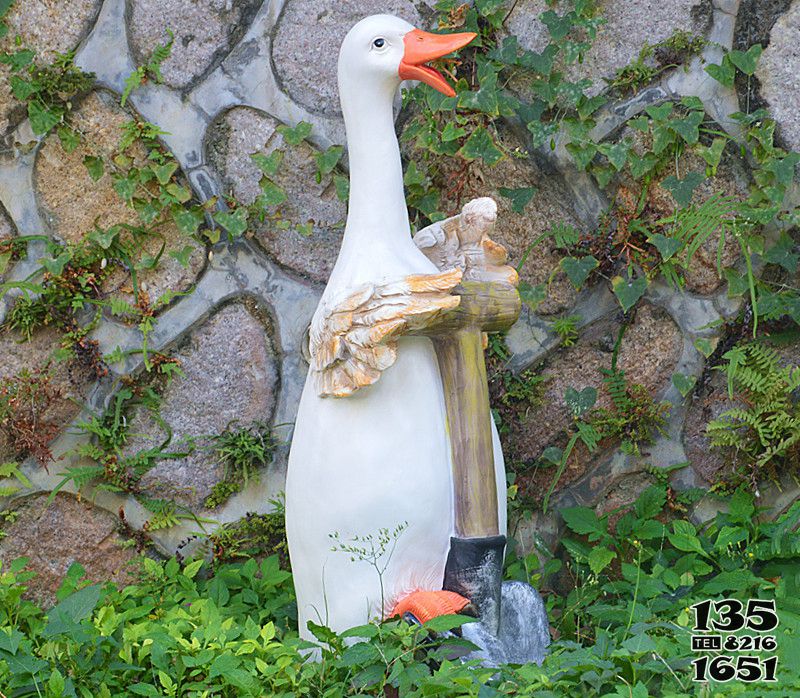 鸭子雕塑-在草地里手拿铲子劳动的玻璃钢卡通鸭子雕塑高清图片