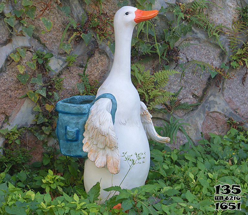鸭子雕塑-在草地里背花篮的玻璃钢卡通鸭子雕塑高清图片