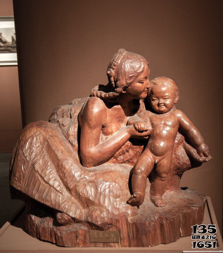 母子雕塑-景区黄蜡石亲吻宝宝的母子雕塑高清图片