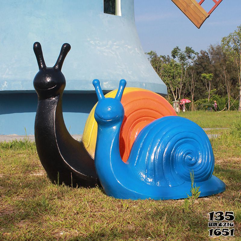 蜗牛雕塑-草地上摆放的一黄一蓝两只玻璃钢彩绘蜗牛雕塑高清图片
