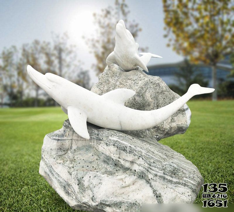 海豚雕塑-公园石头上趴着两只石雕海豚雕塑高清图片
