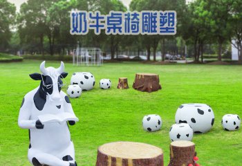 牛雕塑-公园中一只坐着看书的奶牛桌椅玻璃钢牛雕塑