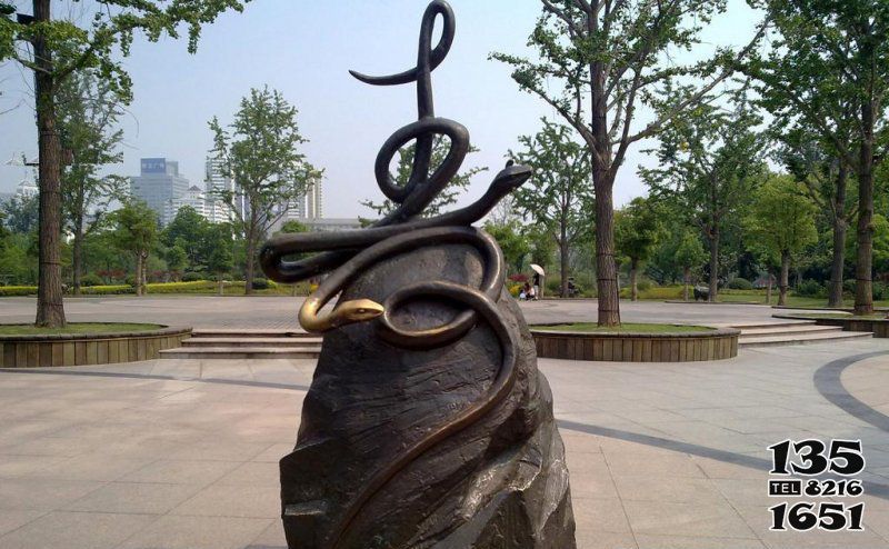 蛇雕塑-公园里摆放的爬在石头上的两条玻璃钢喷漆蛇雕塑