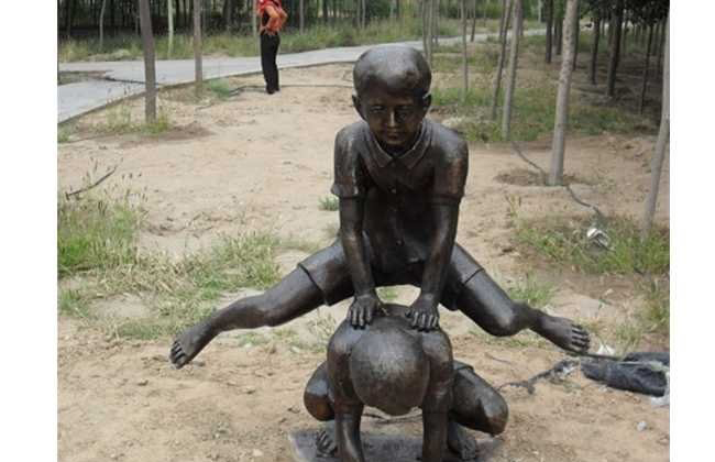 跳山羊的儿童铜雕-铜雕跳山羊的儿童公园童趣雕塑高清图片
